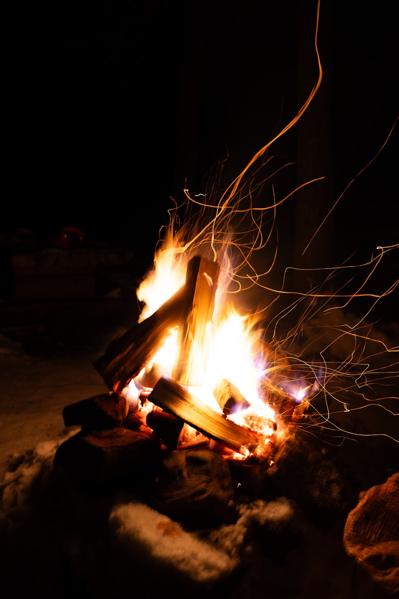 A fire is lit in a dark area